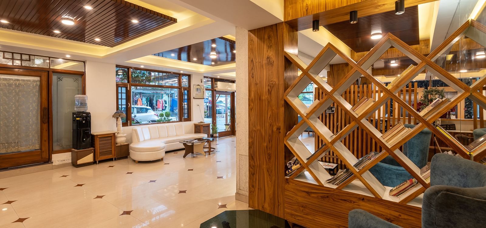 The lobby of DLS Meghavan Resort with comfortable seating, a reception desk, and decorative wooden partitions.